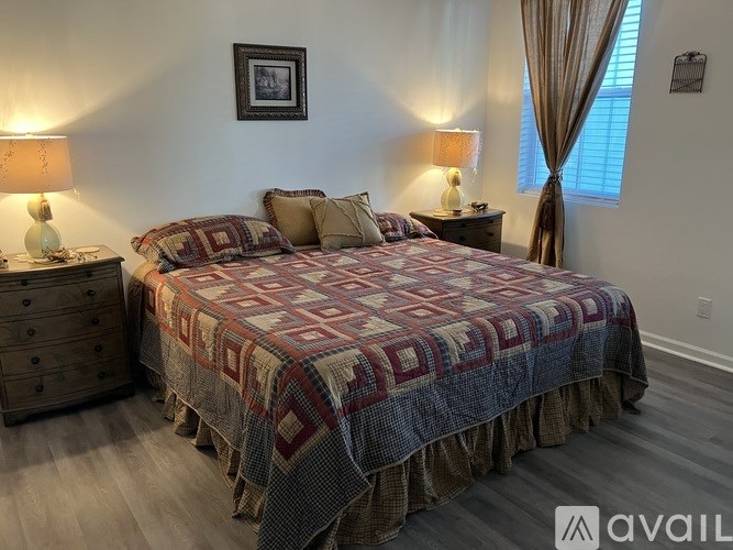 A bedroom with a bed, nightstands, and lamps.