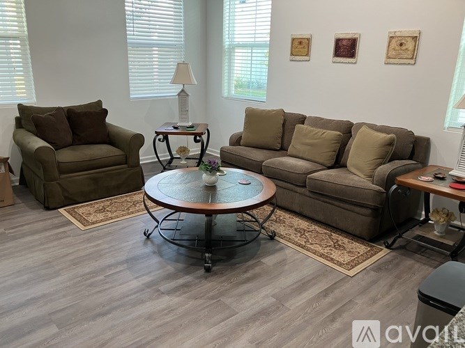 A living room with a brown couch, a chair, and a coffee table.