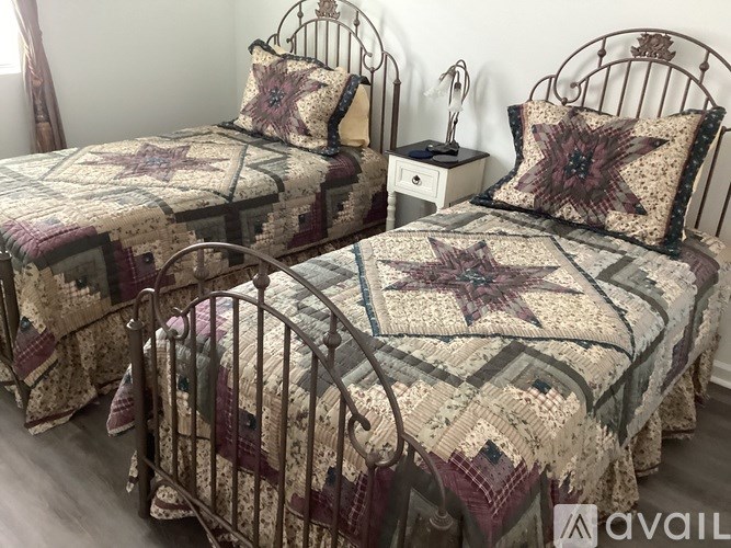 Two beds with star-shaped bedspreads and matching pillows.