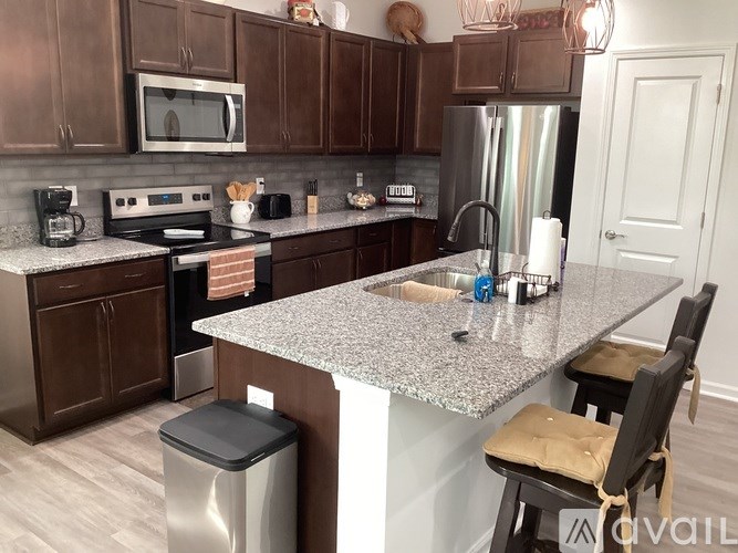 A kitchen with brown cabinets and a granite countertop.