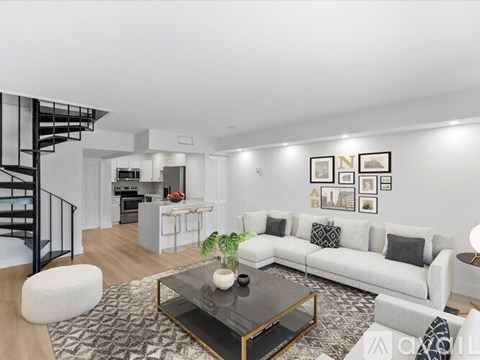 A modern living room with a glass coffee table and a white sofa.