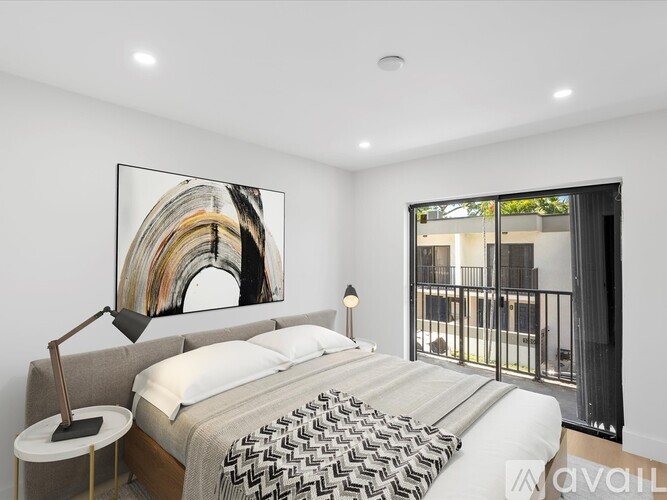 A bedroom with a large bed and a painting on the wall.
