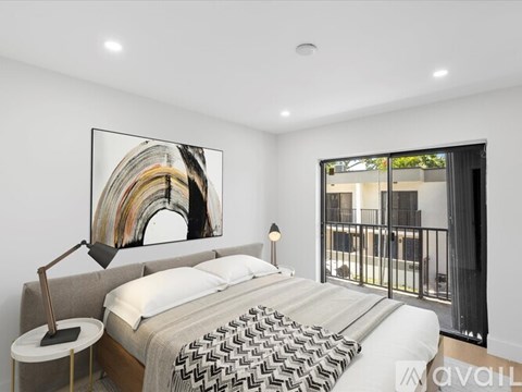 A bedroom with a large bed and a painting on the wall.