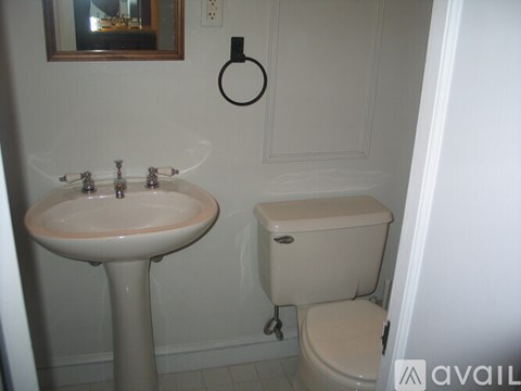 A bathroom with a toilet, sink, and a mirror.