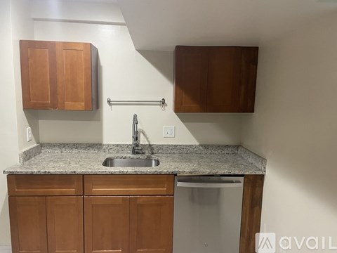 A kitchen with a granite countertop and wooden cabinets.
