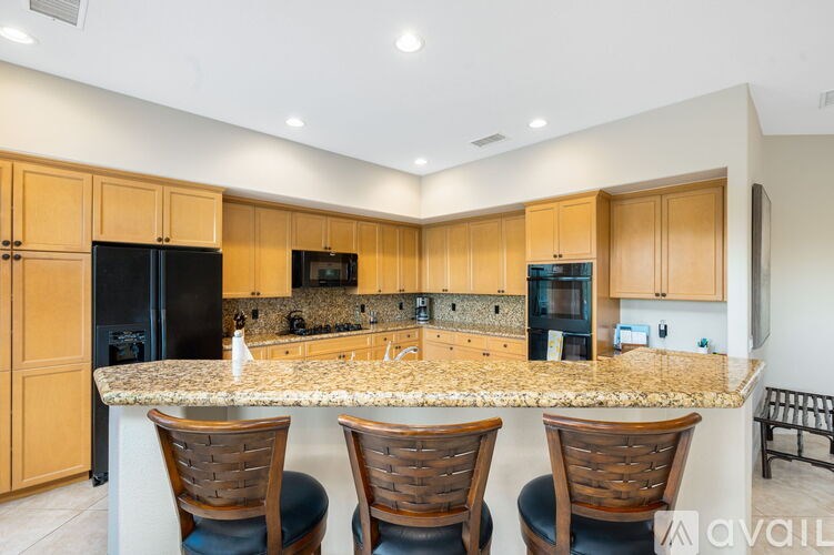A kitchen with wooden cabinets and granite countertops.