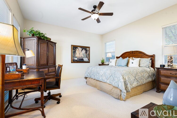 A bedroom with a bed, desk, and chair.