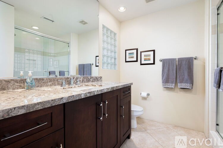 A bathroom with a marble countertop and a large mirror.