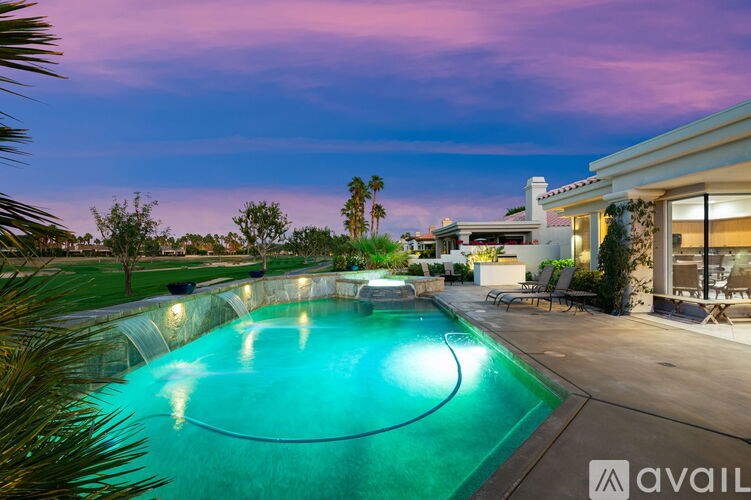 A swimming pool in a backyard with a house in the background.