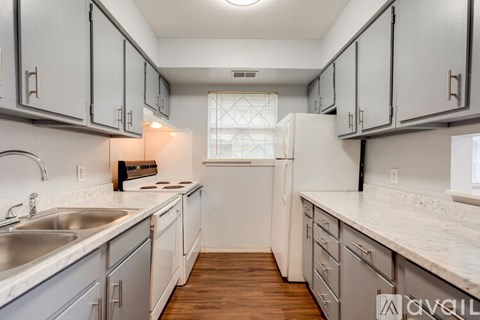 A kitchen with white cabinets and a white fridge.