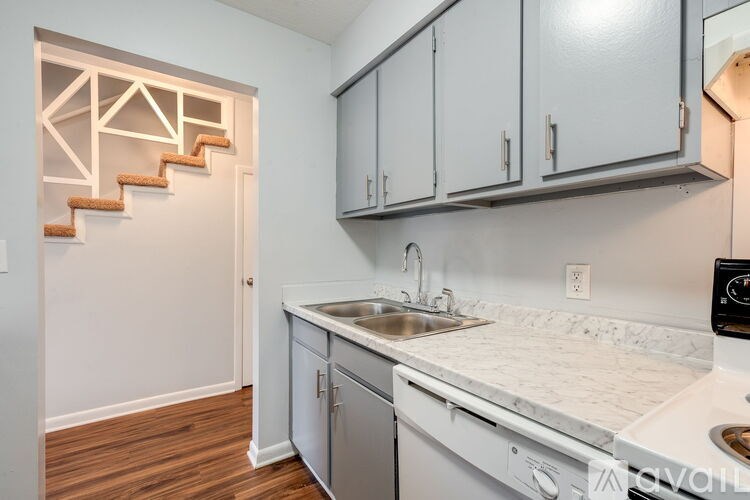A kitchen with a staircase on the wall.