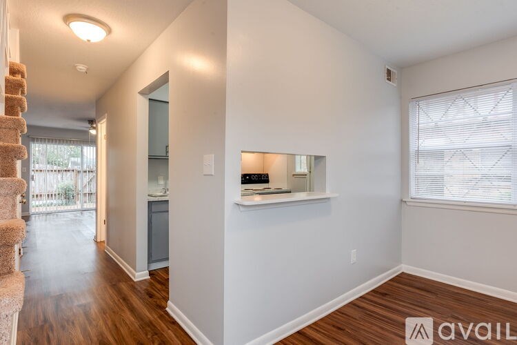 A room with a staircase on the left and a window on the right.