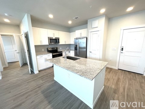 A kitchen with a granite countertop and white cabinets.