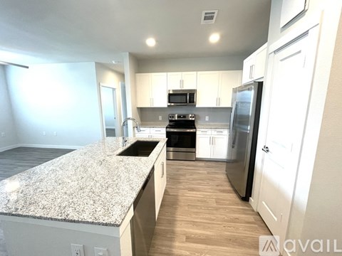 A kitchen with granite countertops and stainless steel appliances.