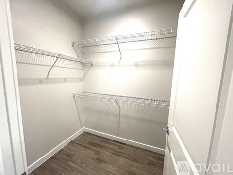 Empty walk-in closet with shelves and wooden floors.