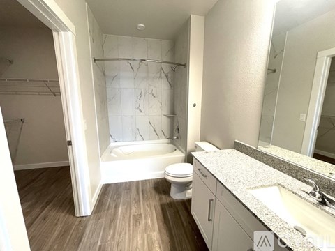 A bathroom with a toilet, sink, and marble shower.