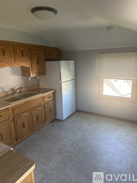 A kitchen with wooden cabinets and a white refrigerator.