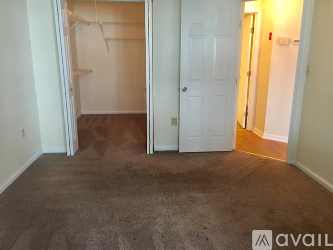 A room with a carpeted floor and a white door.