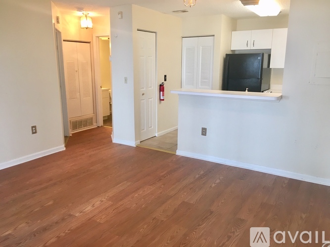 A living room with a television on a white shelf.