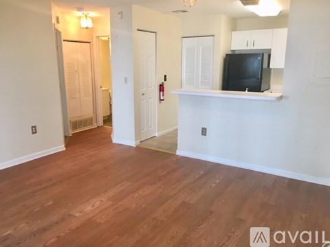 A living room with a television on a white shelf.