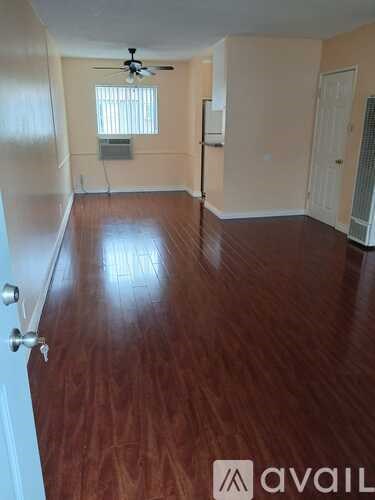 A room with wooden flooring and a ceiling fan.