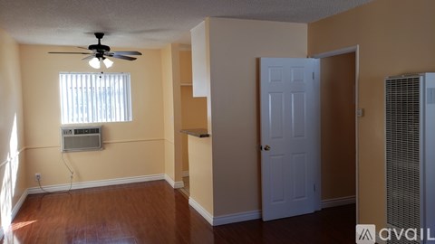 A room with a ceiling fan and a window with blinds.