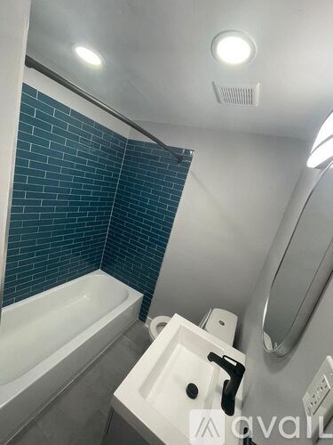 A bathroom with a white sink and a white bathtub.