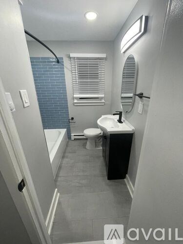 A bathroom with a toilet, sink, and mirror.