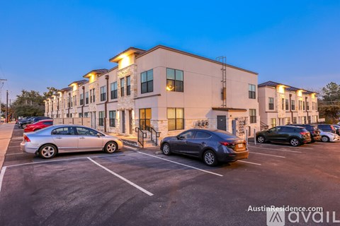 A parking lot with cars and a building in the background.