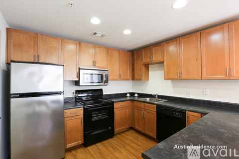 A kitchen with wooden cabinets and black countertops.