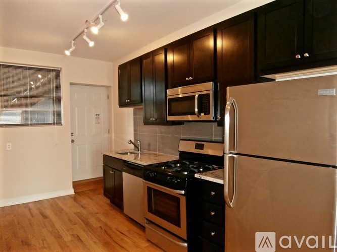 A kitchen with a stainless steel refrigerator, microwave, and oven.