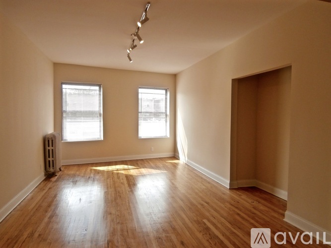 A room with wooden floors and two windows.