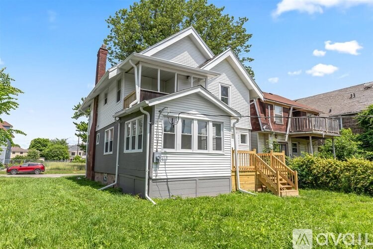 A house with a red car parked in front.