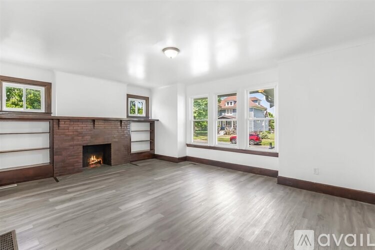 A living room with a fireplace and wood flooring.