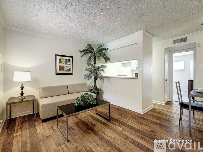 A living room with a couch, a table, and a plant.