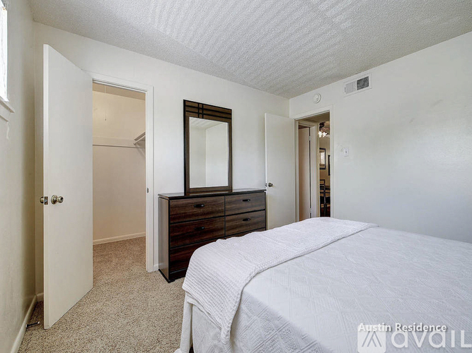 A bedroom with a bed, dresser, and mirror.