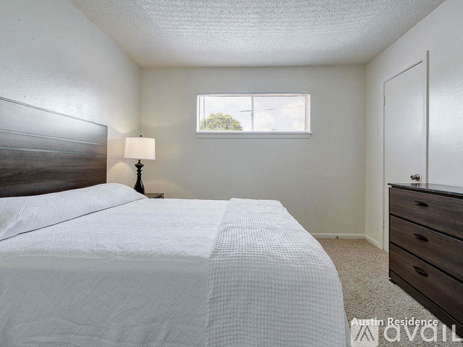 A bedroom with a bed, dresser, and window.