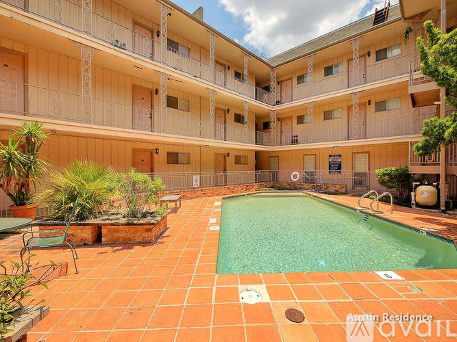 A large outdoor pool surrounded by a patio and balconies of a residential building.