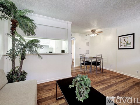 A living room with a couch, a dining table and a plant.