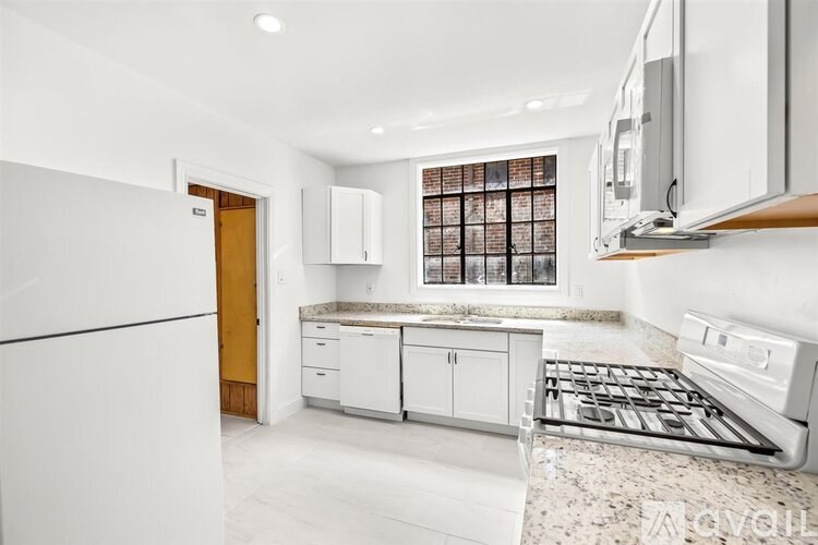 A kitchen with white appliances and a marble countertop.