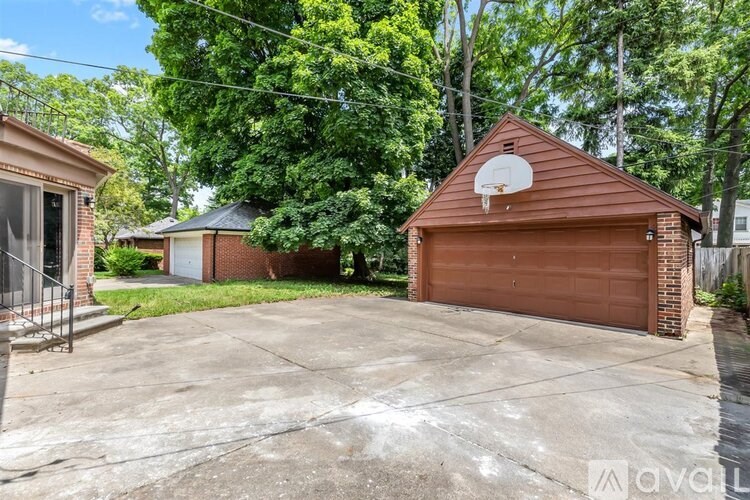 A basketball hoop is mounted on the side of a garage.