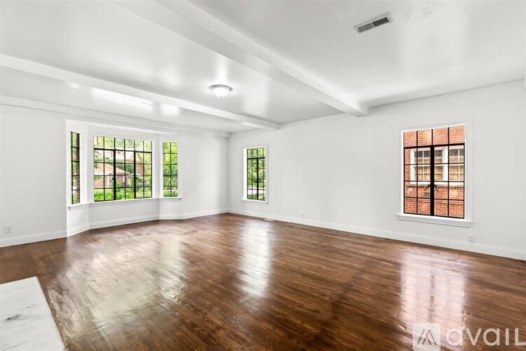 A spacious room with wooden floors and white walls.