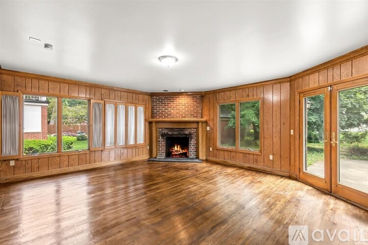 A large room with a fireplace and wood flooring.