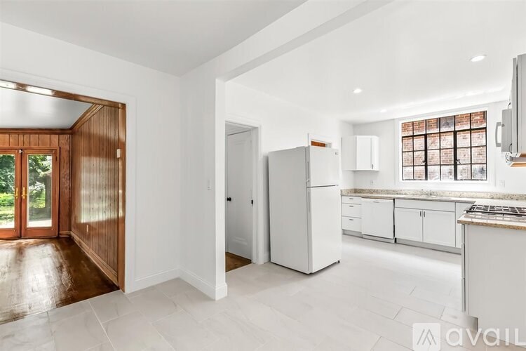 A kitchen with white cabinets and a white fridge.