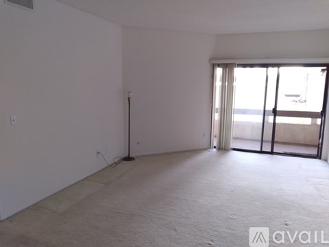 A room with a sliding glass door leading to a balcony.