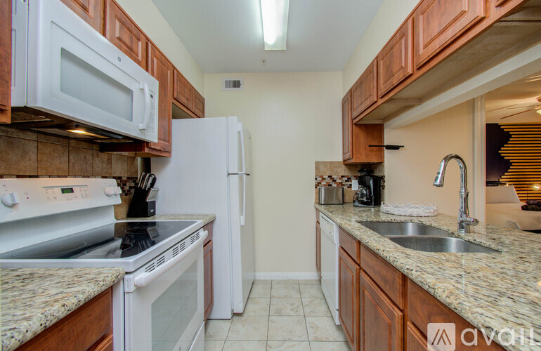 A kitchen with brown cabinets and white appliances.