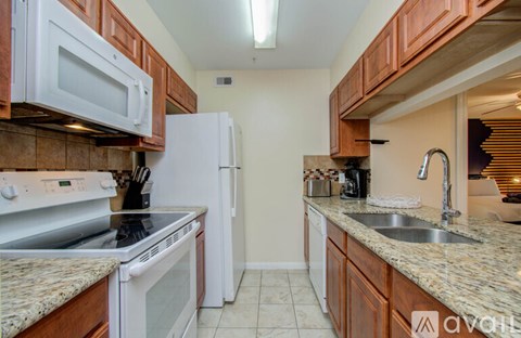 A kitchen with brown cabinets and white appliances.