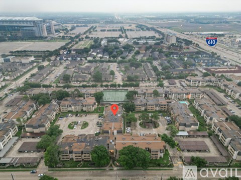 An aerial view of a neighborhood with apartment buildings and a road sign for 610.