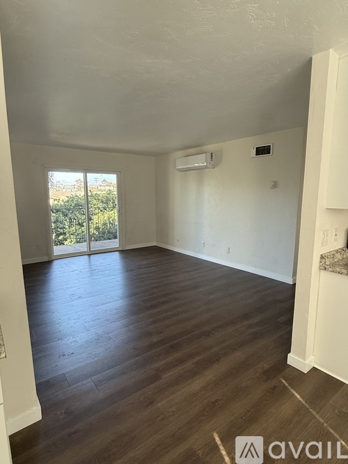 A room with wooden flooring and a brown door.