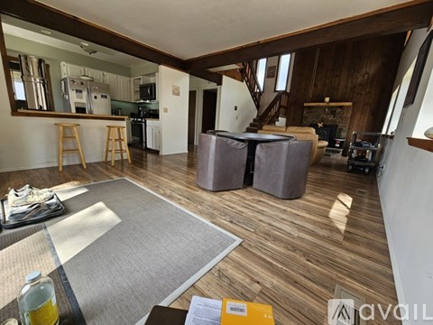 A living room with a grey rug and wooden floors.
